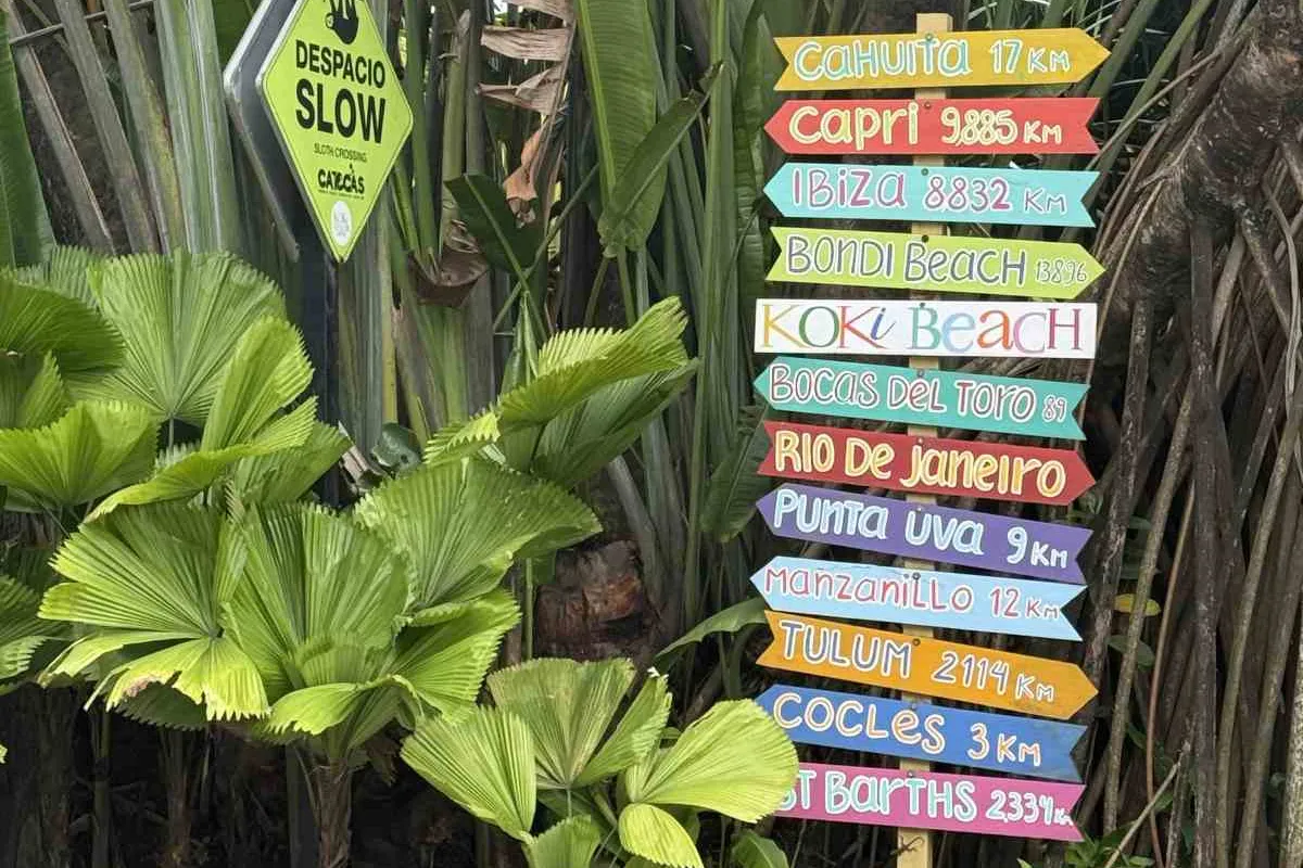 Bunter Wegweiser mit Entfernungen nach Cahuita, Punta Uva, Manzanillo und in die ganze Welt